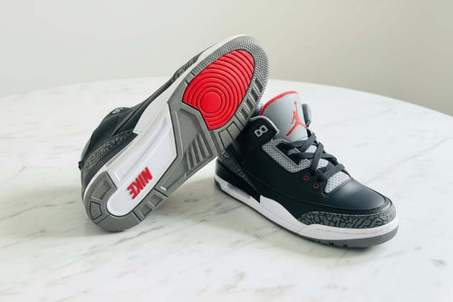 Scarpe Jordan per prestazioni sportive su un tavolo con fondo neutro, design elegante e dettagli distintivi.