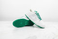 Scarpe Nike per attività sportive con design bianco e verde su sfondo bianco.