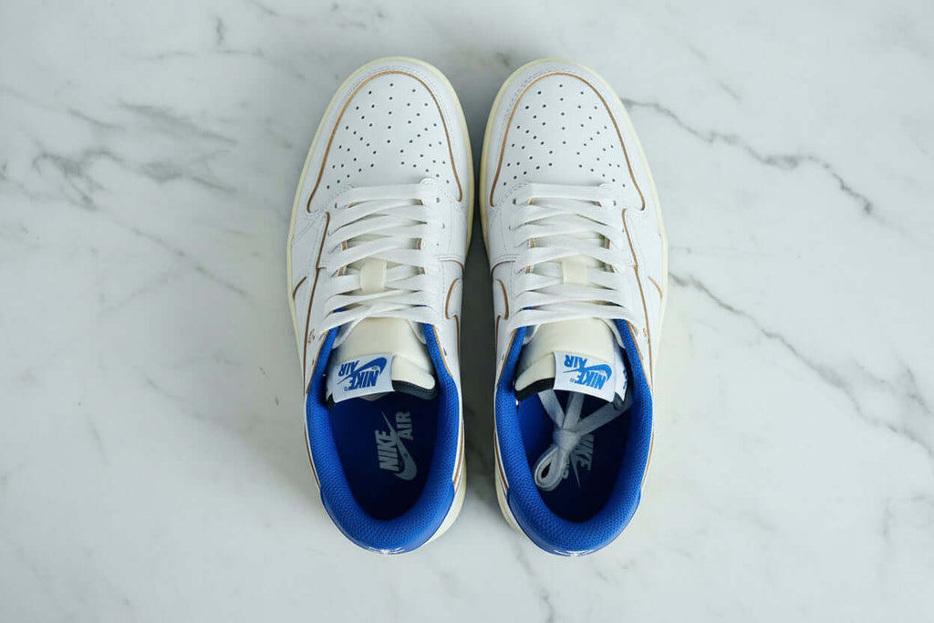 Nike performance sports shoes in white and blue colorway, featuring a perforated upper and signature Nike branding.