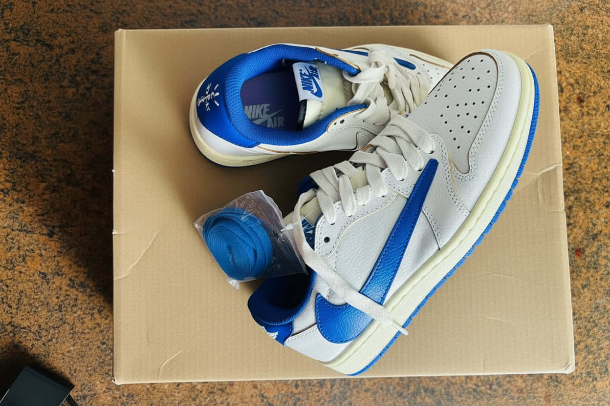 Nike performance sports shoes displayed on a box, featuring blue accents and laces.